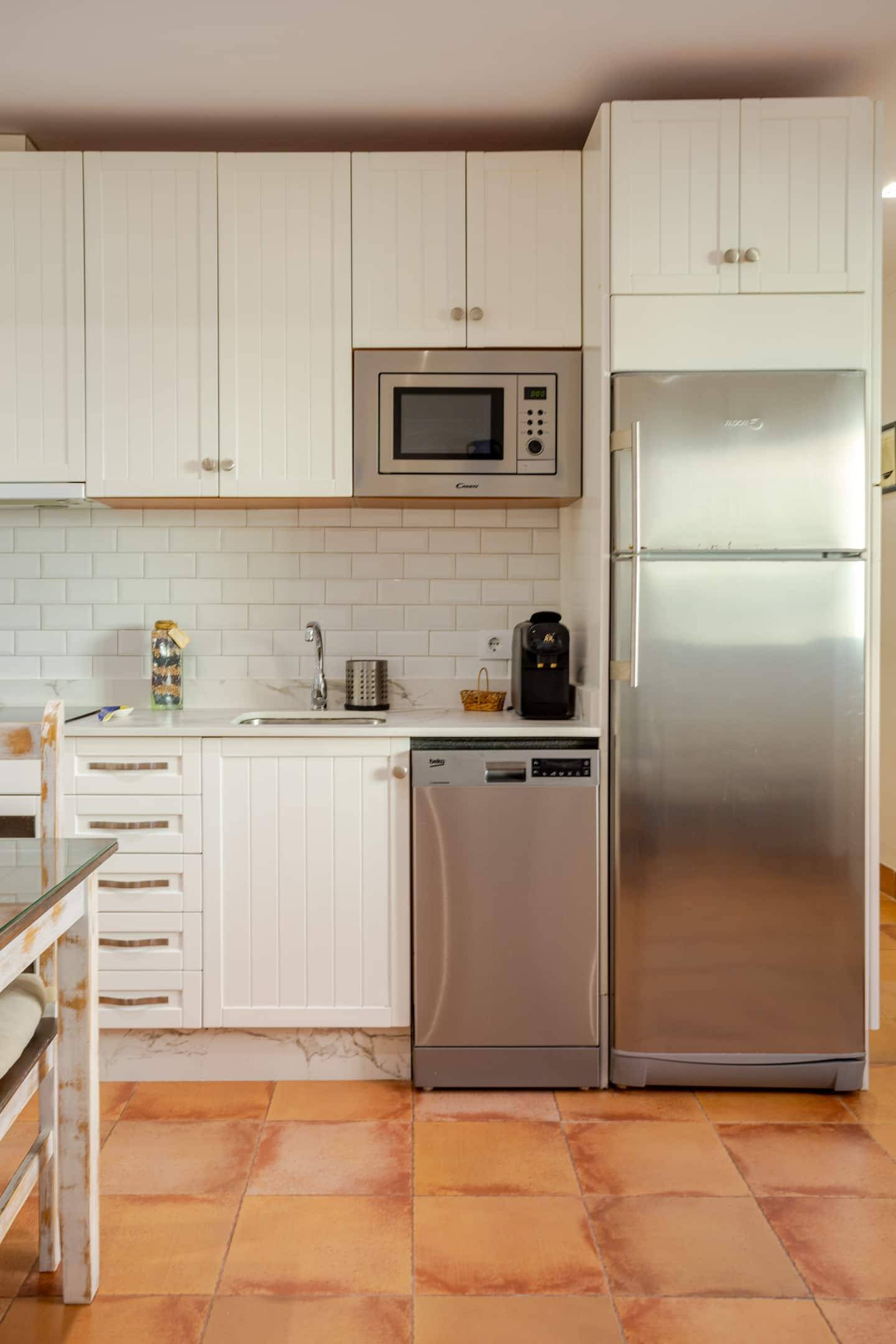 Cocina del apartamento con zona de almacenaje y electrodomésticos